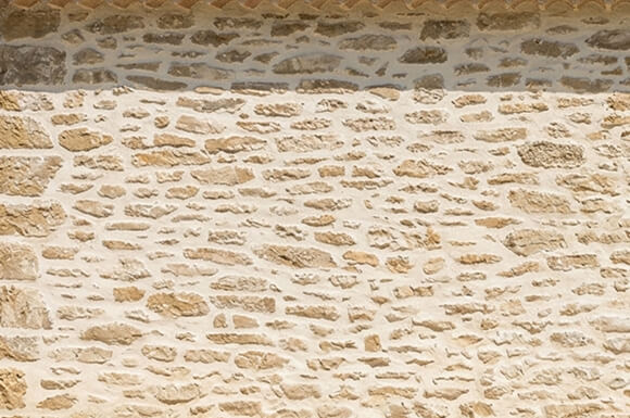 Nettoyage basse pression sur une façade en enduit et pierre